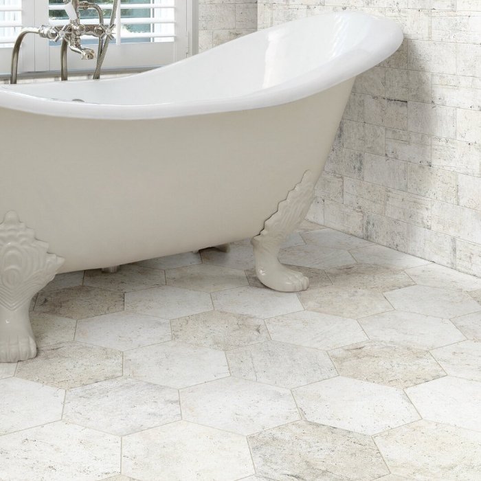 Classic claw foot tub in a bathroom with hexagonal tile floors