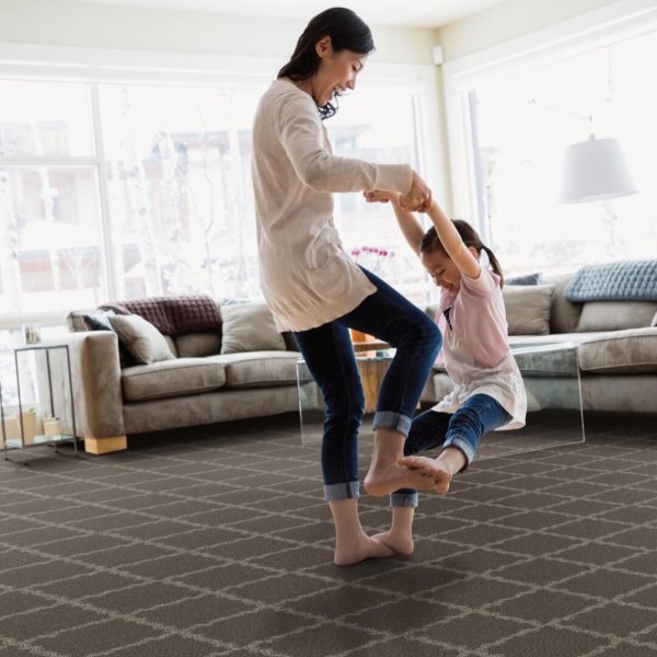 Mother and child playing in a family home with patterned carpet floors
